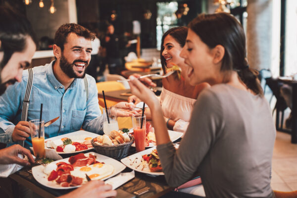 Group of Happy friends having breakfast in the restaurant